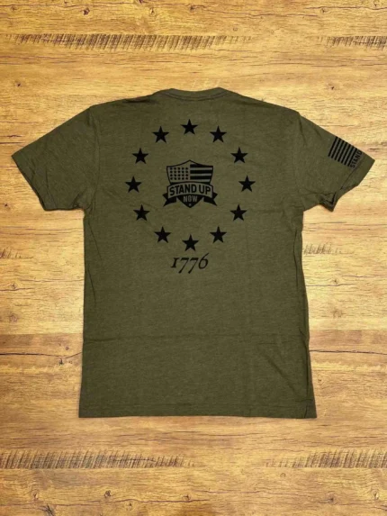 Stand Up Boldly and show your American patriotism in this comfortable shirt. FREEDOM over FEAR is the perfect expression of what a patriotic shirt should be. 1776 betsy ross flag on the back. Shirt comes in black, sand, grey & green